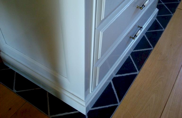 Stijlkeuken op maat, de aansluiting tussen de keukenvloer en de houten vloer in de woonkamer.